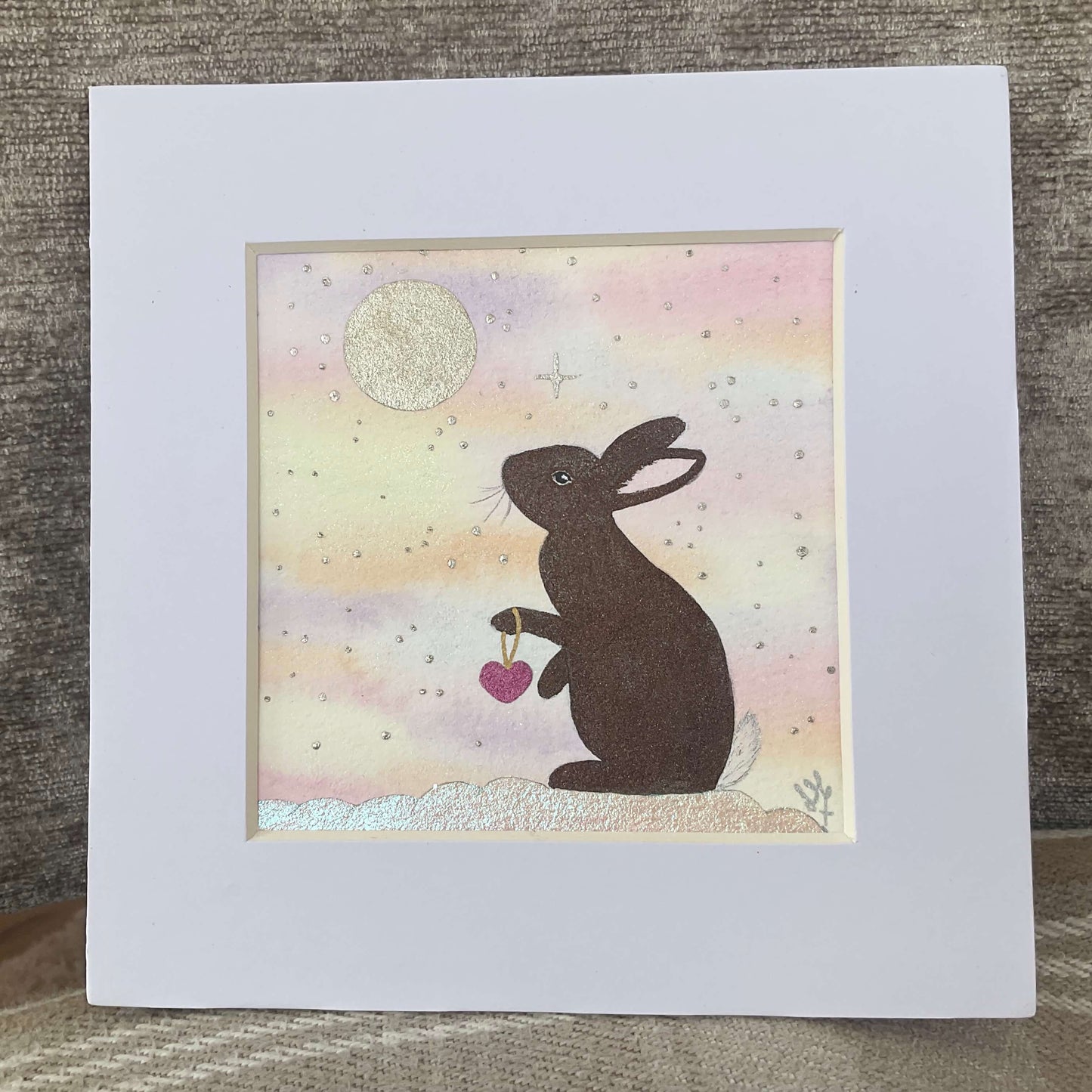 Original brown bunny art print titled A Love Kept in the Stars featuring a whimsical watercolor rabbit stargazing under a midnight blue sky with gold stars