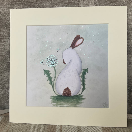 Hand-finished storybook bunny print titled And Every Wish is For You showing a white rabbit with a shimmering iridescent dandelion clock on a sage green background