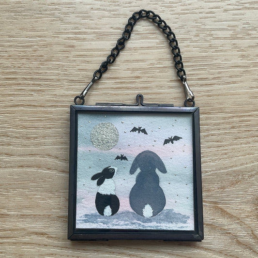 Original mini watercolor painting titled Batty About You featuring two rabbit silhouettes sitting together under a metallic silver moon and bats.