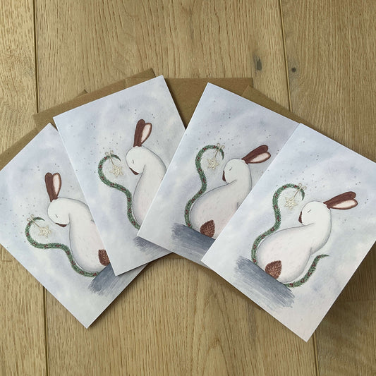 A pack of four luxury Christmas greeting cards printed in the UK featuring the whimsical My Christmas Star white rabbit artwork against a frosty blue background