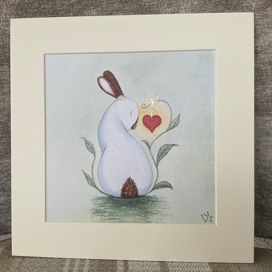 Hand-embellished watercolor art print titled My Heart is Yours featuring a whimsical white rabbit looking at a red heart vine against a soft sage green background.