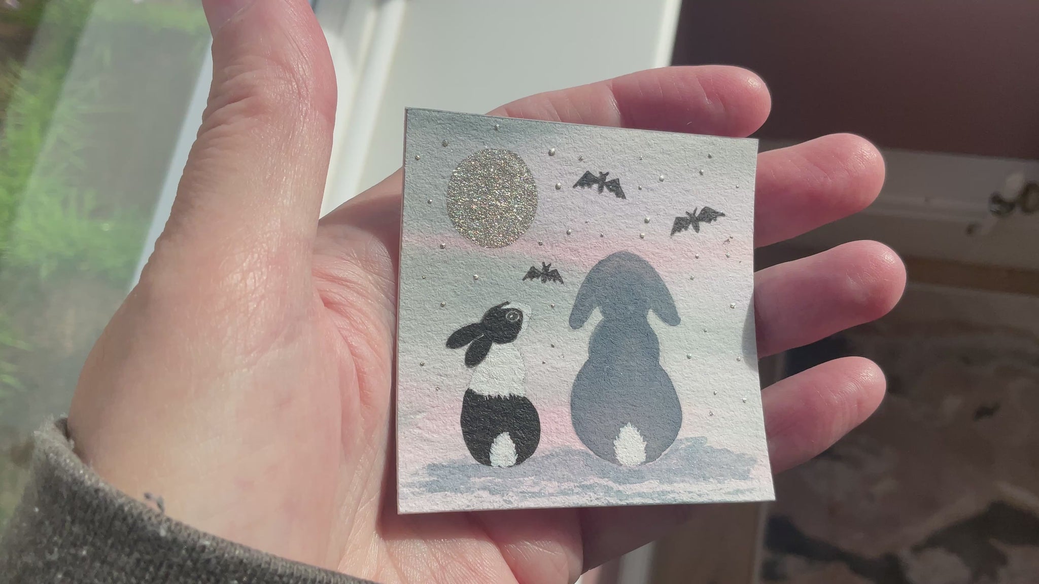 Video of Original mini watercolor painting titled Batty About You featuring two rabbit silhouettes sitting together under a metallic silver moon and bats.